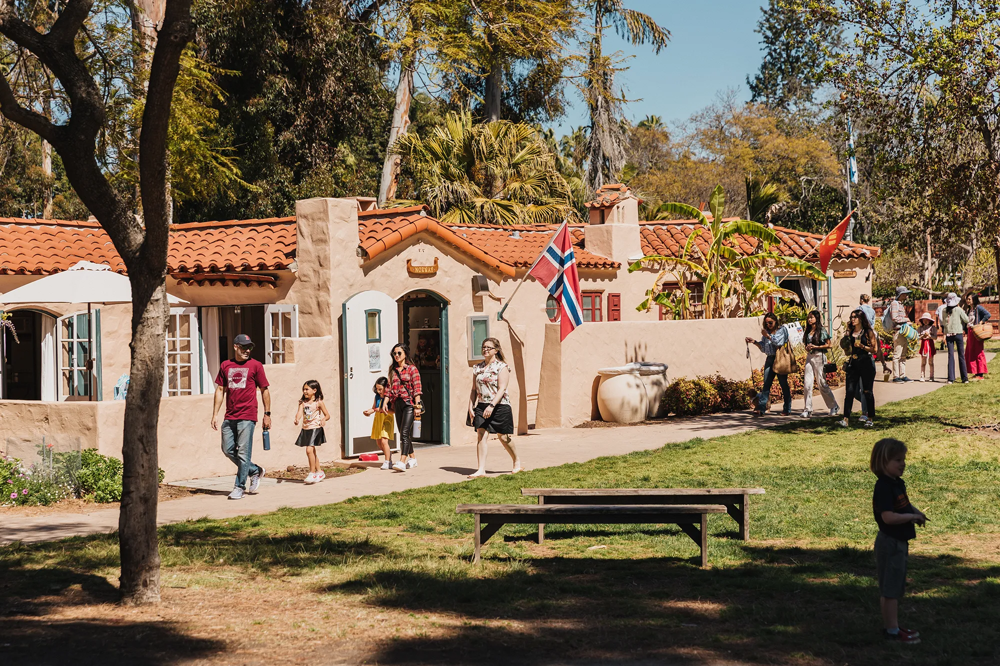 Visitors walking along a pathway in front of the House of Pacific Relations International Cottages.