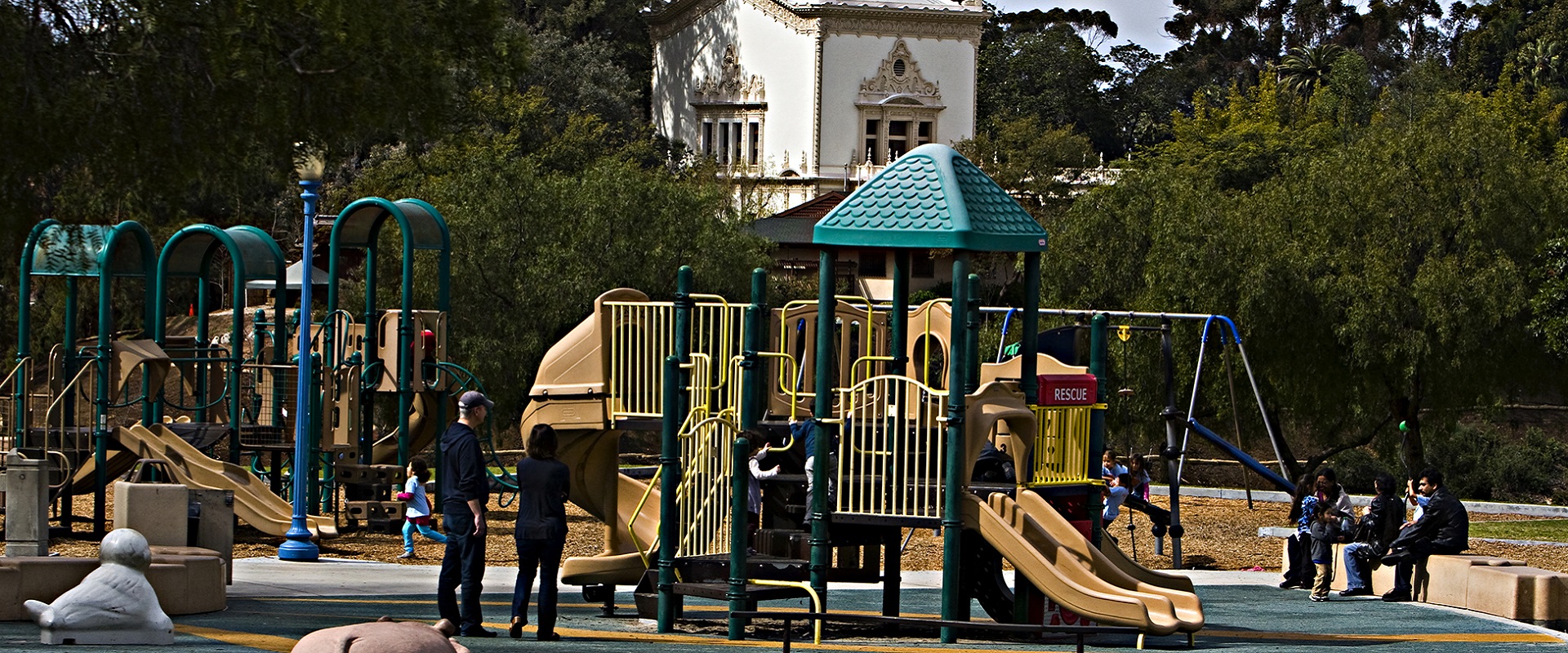 Pepper Grove playground where children are playing on large colorful play structures, slides, and swings.