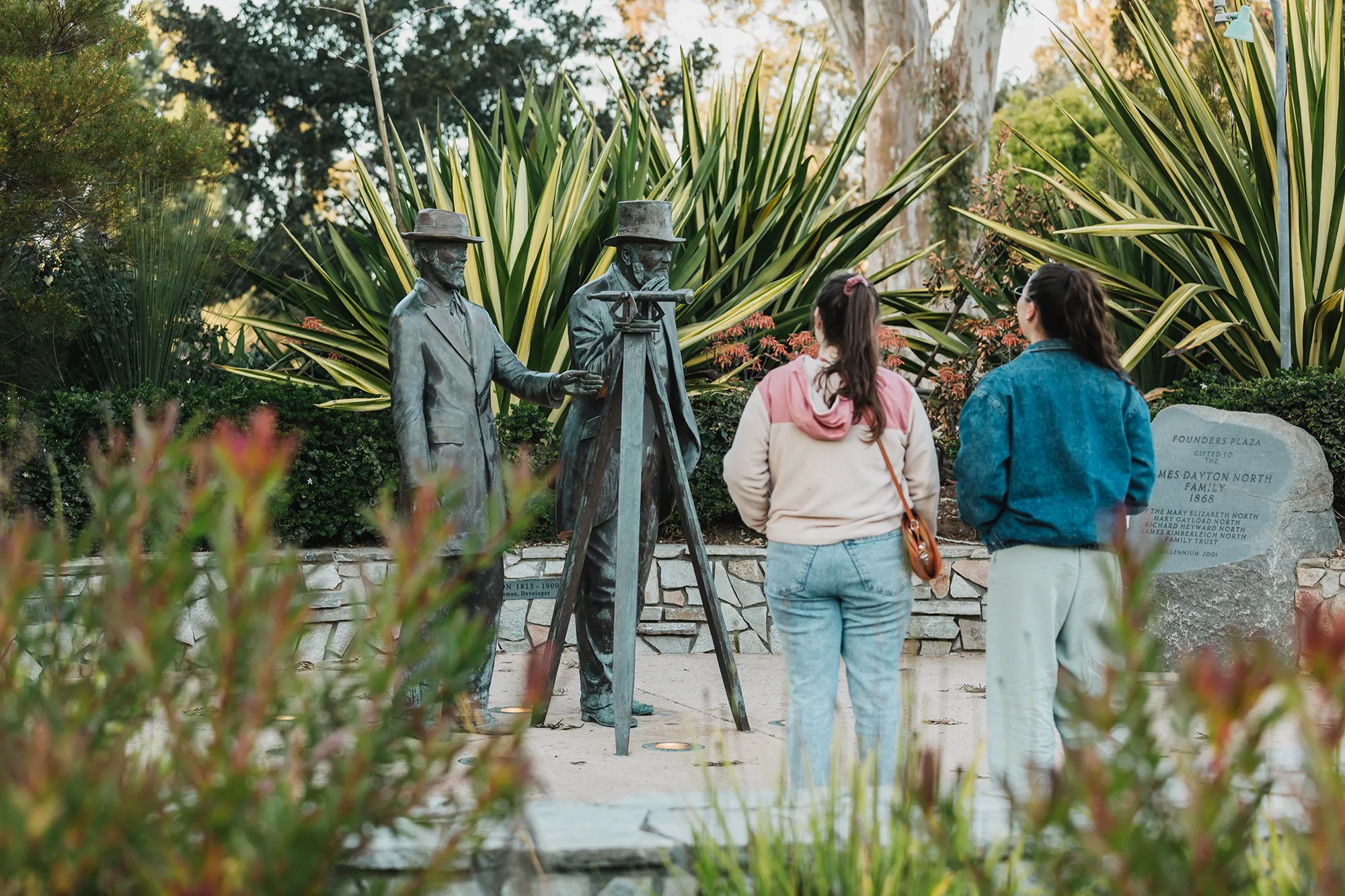 Two people looking two statues in Sefton Plaza in Balboa Park.