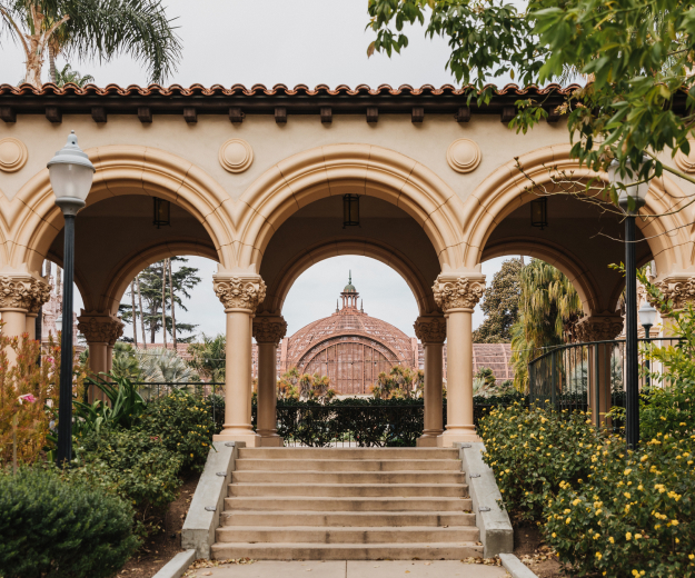 A view of the Balboa Park Botanical Building roof looking through the arch of a covered walkway