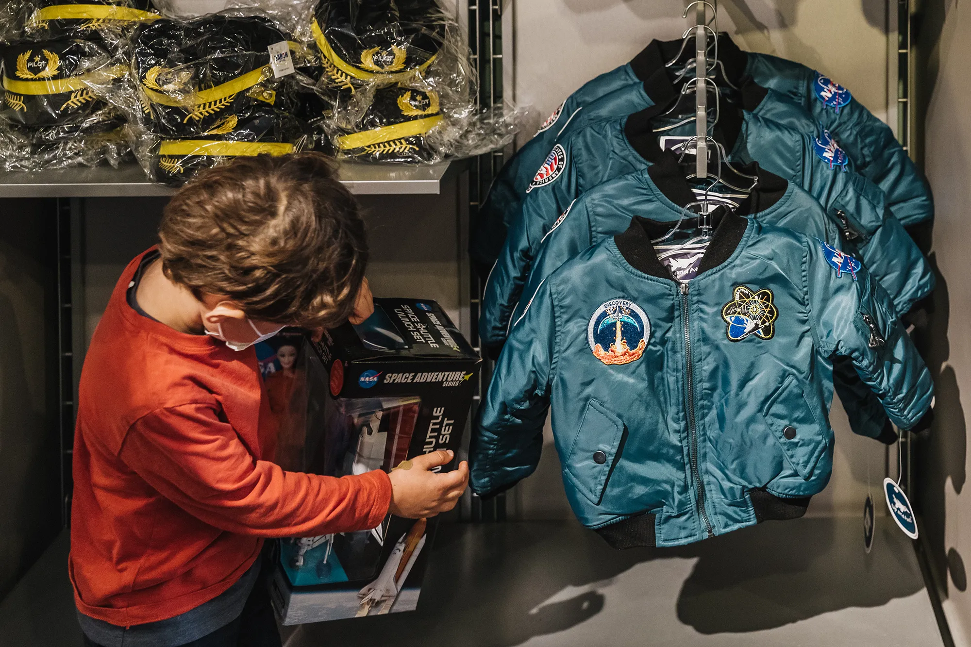 A child looking at a space shuttle model in the San Diego Air and Space Museum gift shop.