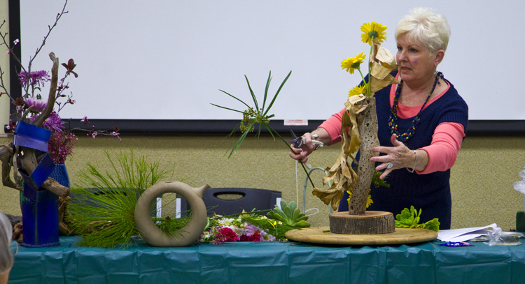 A person putting together a floral display from the San Diego Botanical Garden Foundation.