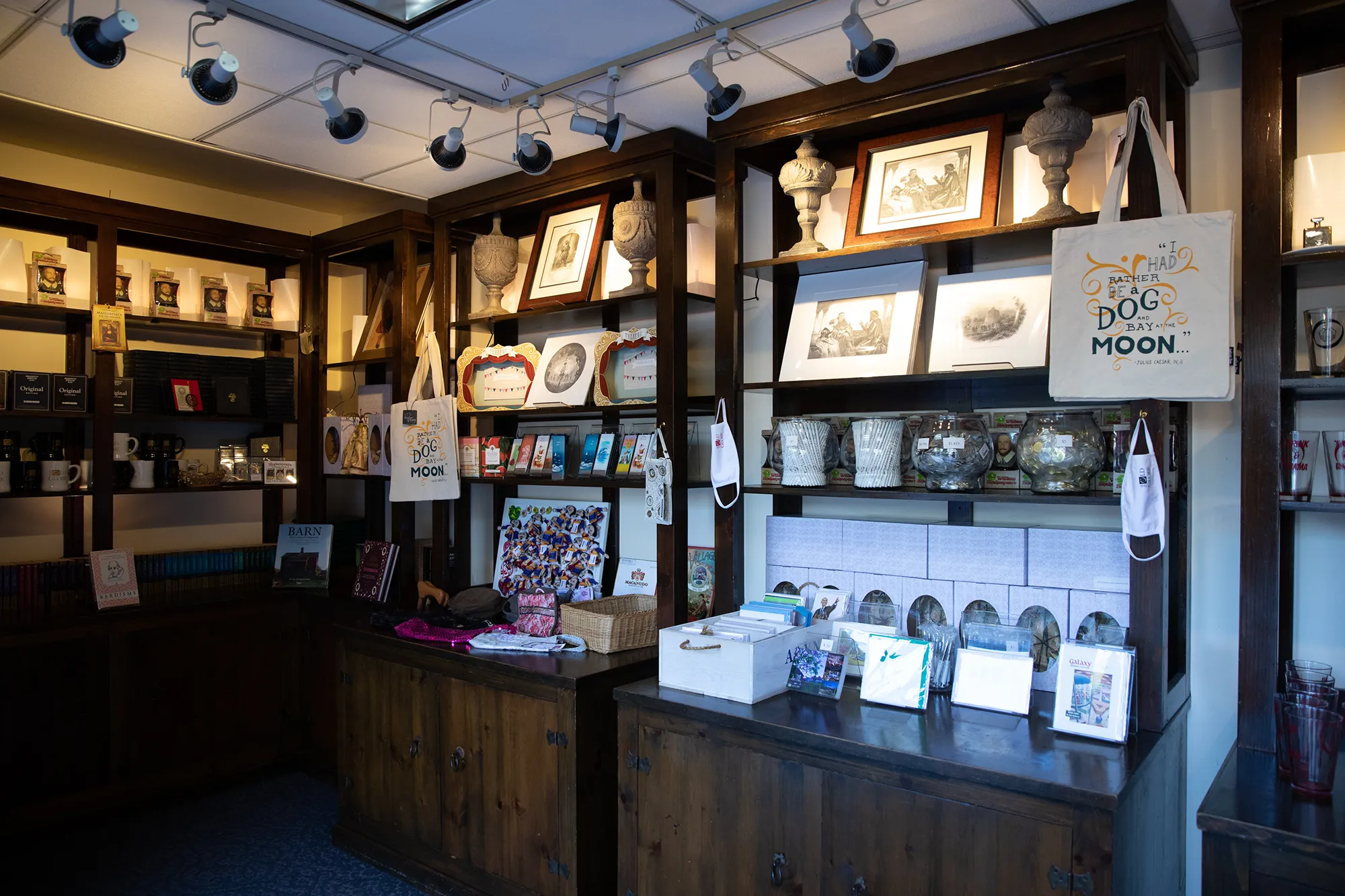 Tote bags, framed pictures, pottery, and other various items on display at the Helen Edison Gift Shop at the Old Globe.