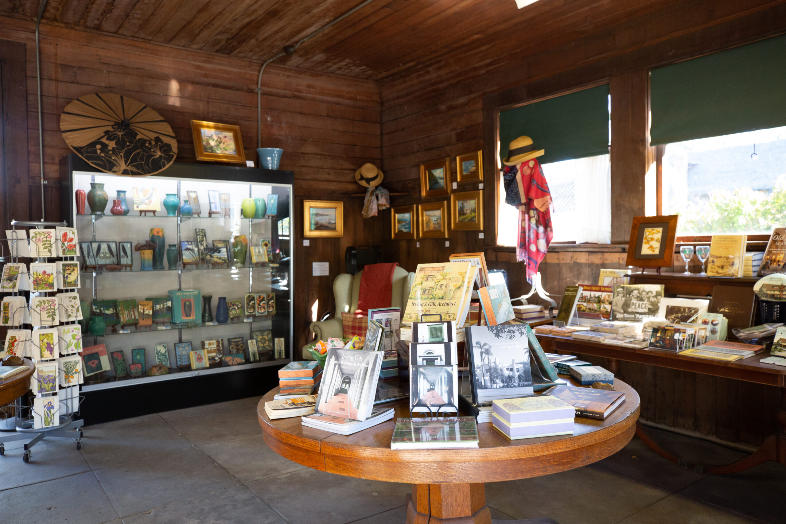Interior of the Marston House Museum Shop. Various books, postcards, hats, and other items are on display for purchase.