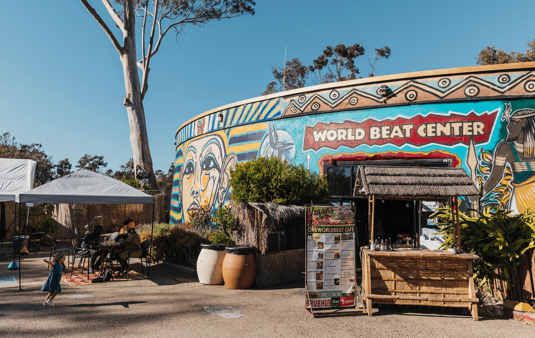 The entrance to the World Beat Center. The building is covered in bright and colorful murals.
