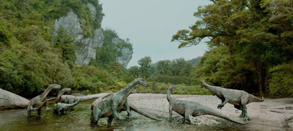 dinosaurs standing on a river bank