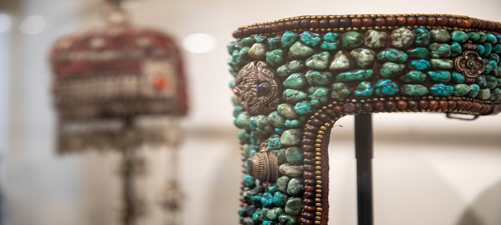 blue and green beads on a structure between brown beading and with silver adornments