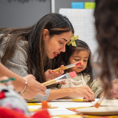 Woman painting with a little girl