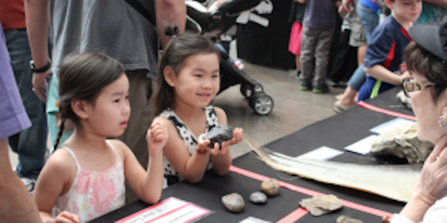 little girls holding rocks at a table