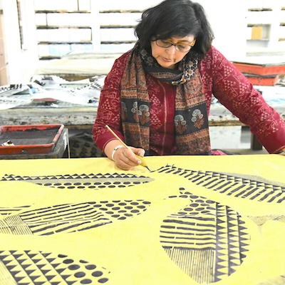 woman painting leaves on a yellow background